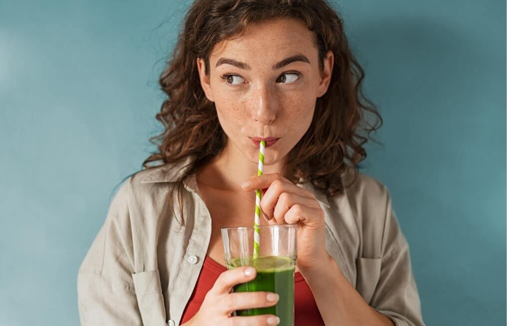 young-woman-drinking-detox-juice-with-straw-on-blu-2023-11-27-05-02-18-utc (2)
