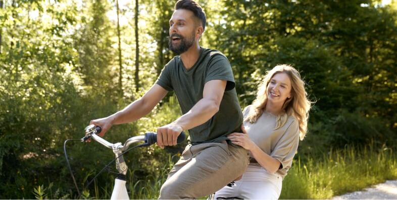 Playful couple having fun on a bike in the woods 2024 12 03 21 42 41 utc (2)